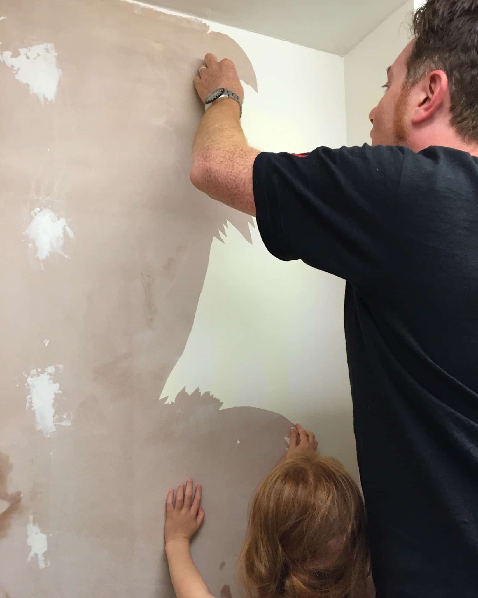 Ryan and Ava peeling old paint off the utility room wall