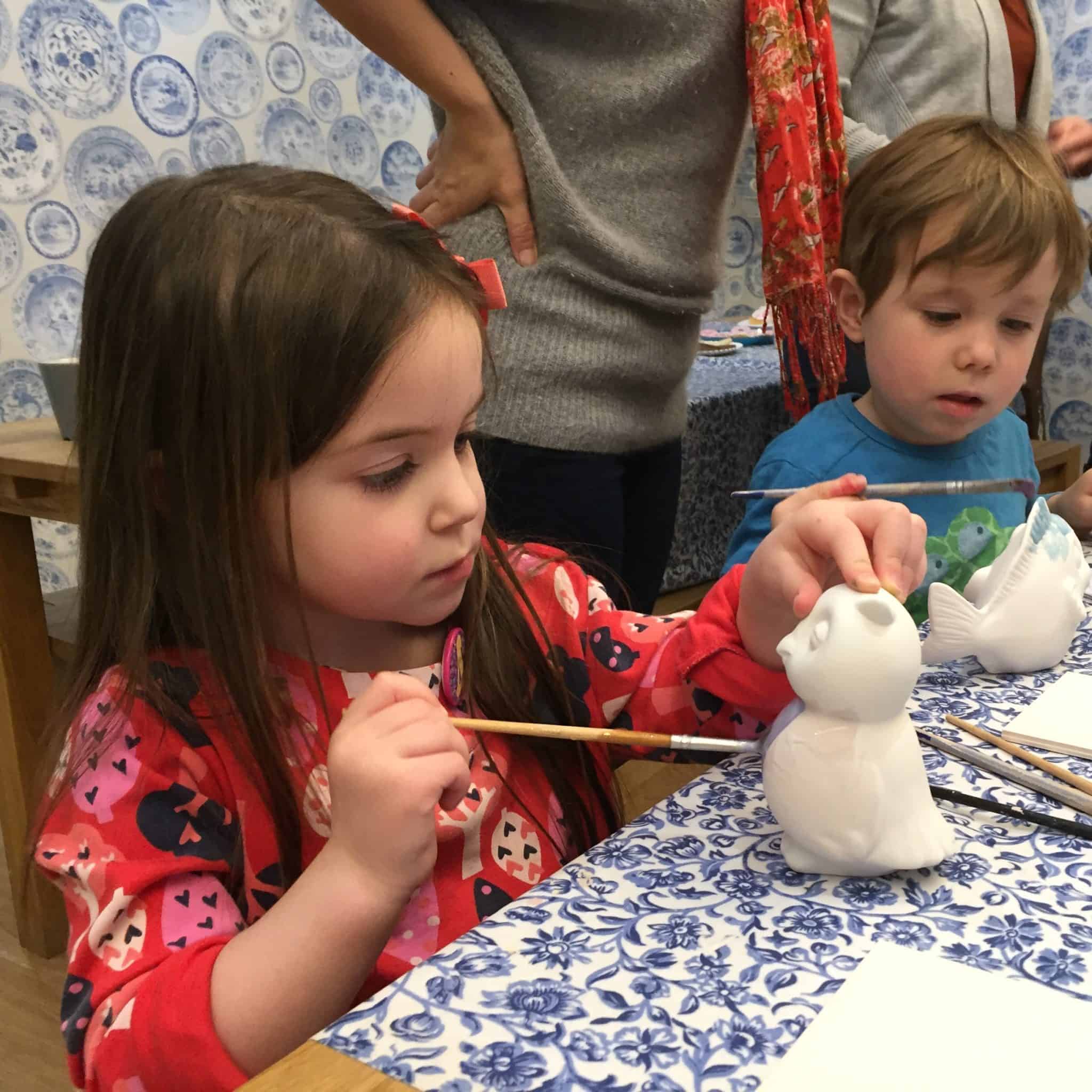 Thea painting her pottery