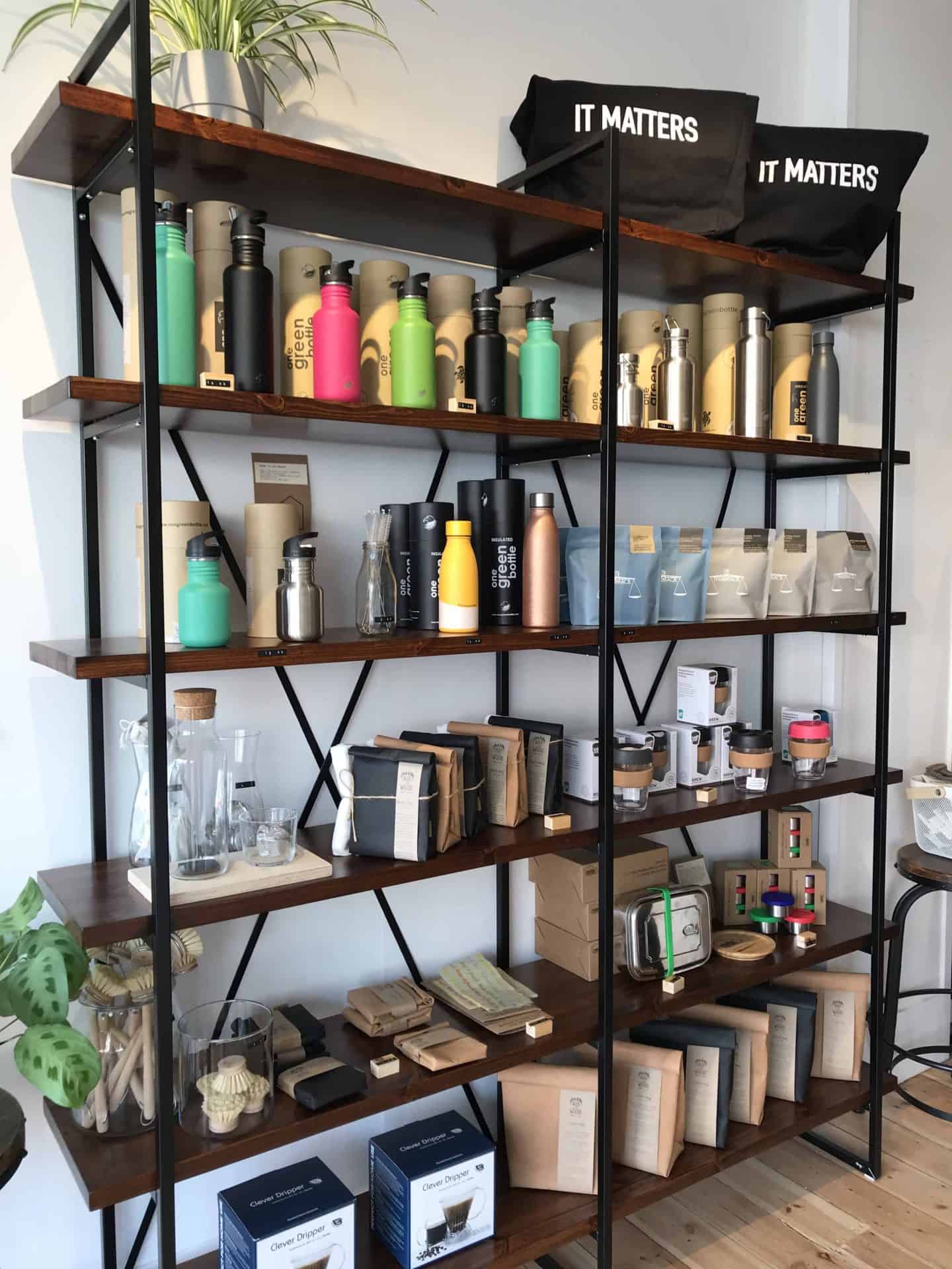 Reusable water bottles and bags, and other eco-friendly products on shelves at Barnes + Binns in Hove