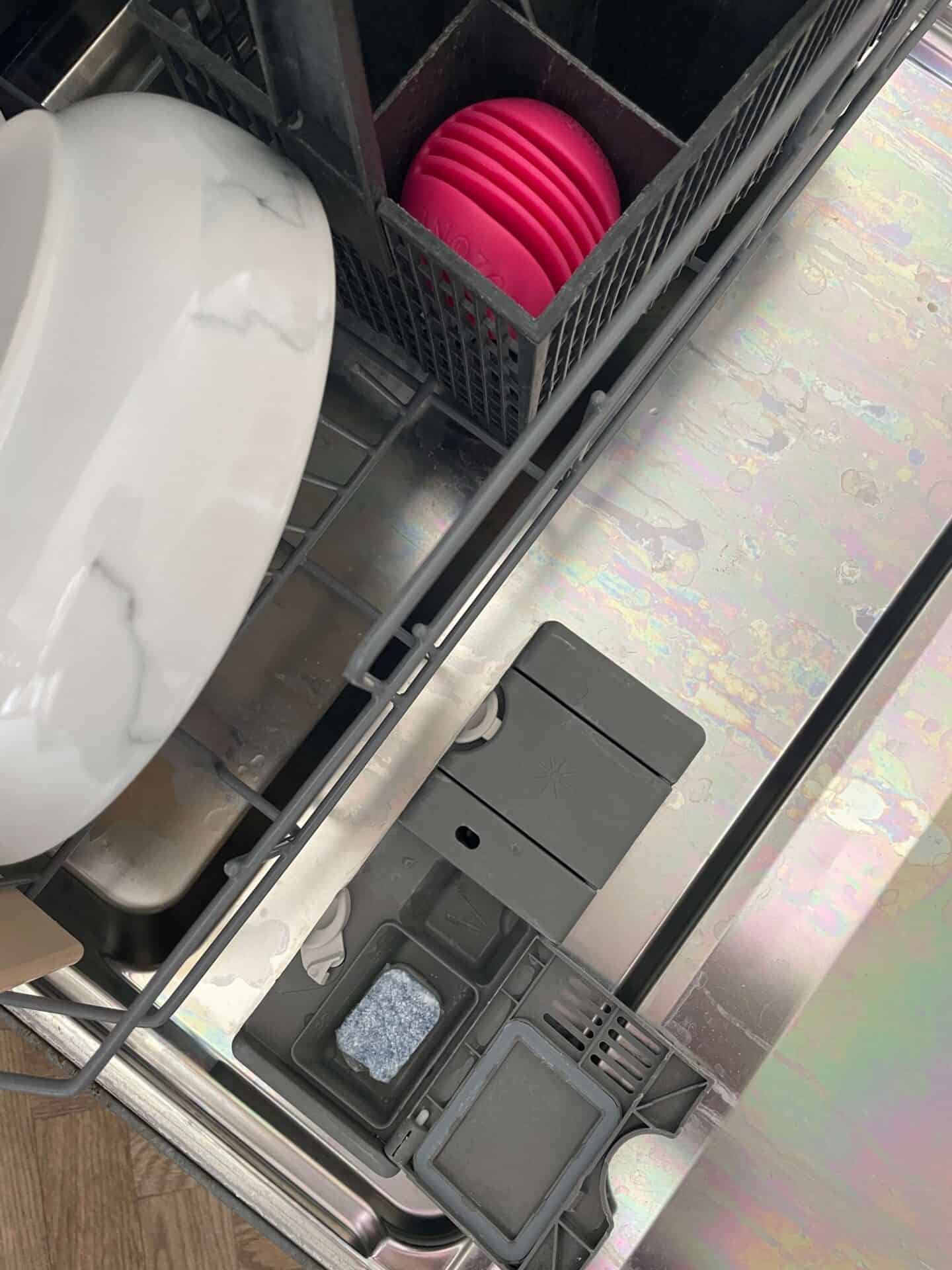 An open dishwasher with an EcoZone MagnoBall and Dishwasher tablet