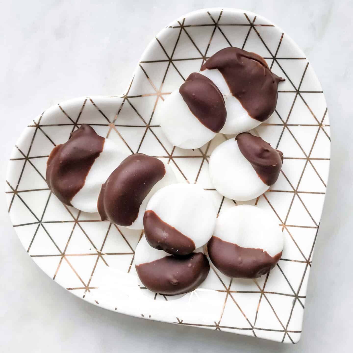 A heart-shaped plate of homemade peppermint creams dipped in dark chocolate