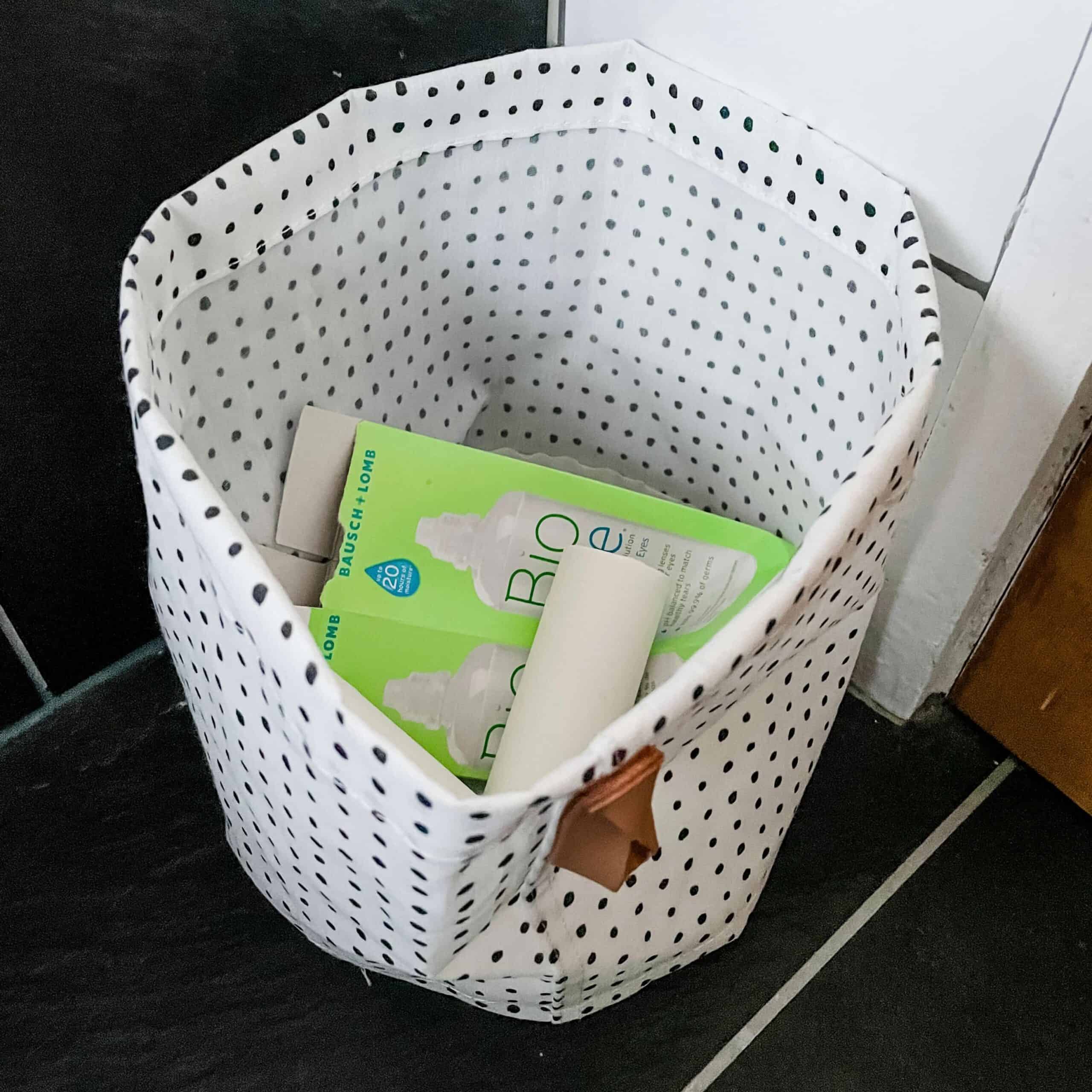 A bathroom recycling bin with cardboard recycling