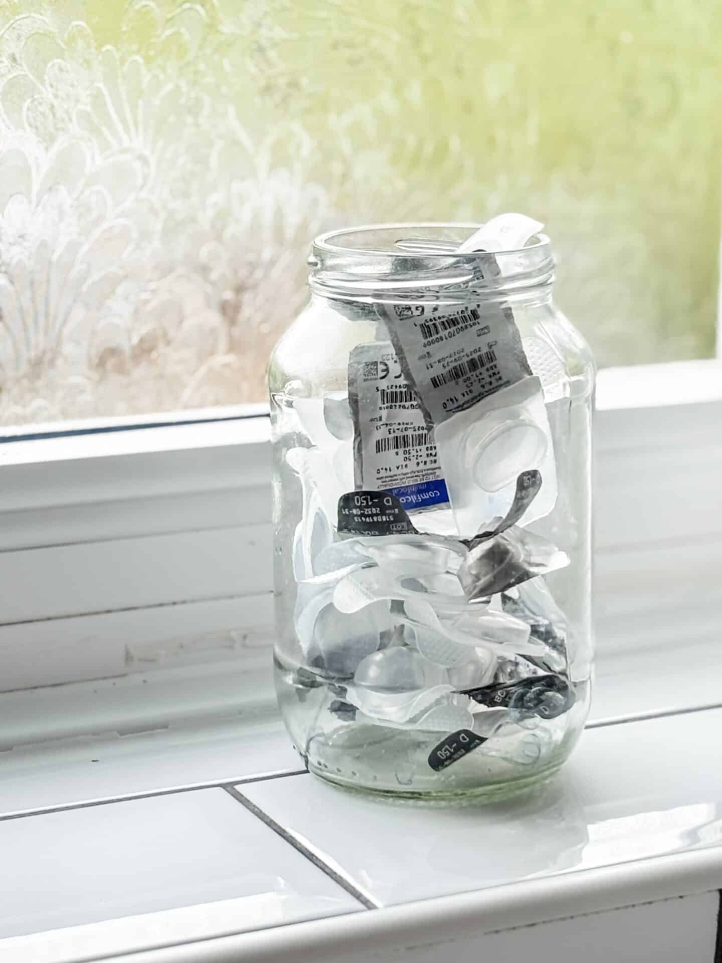 Contact lens cases in a reused glass jar waiting to be recycled