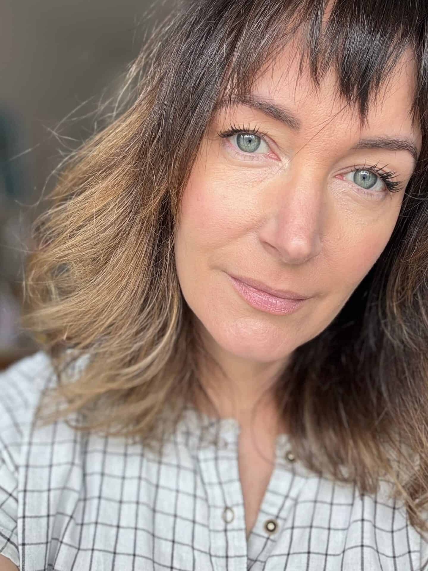 A white woman wearing Husk & Seed Natural Mineral Sunscreen SPF30 beneath make-up in the morning