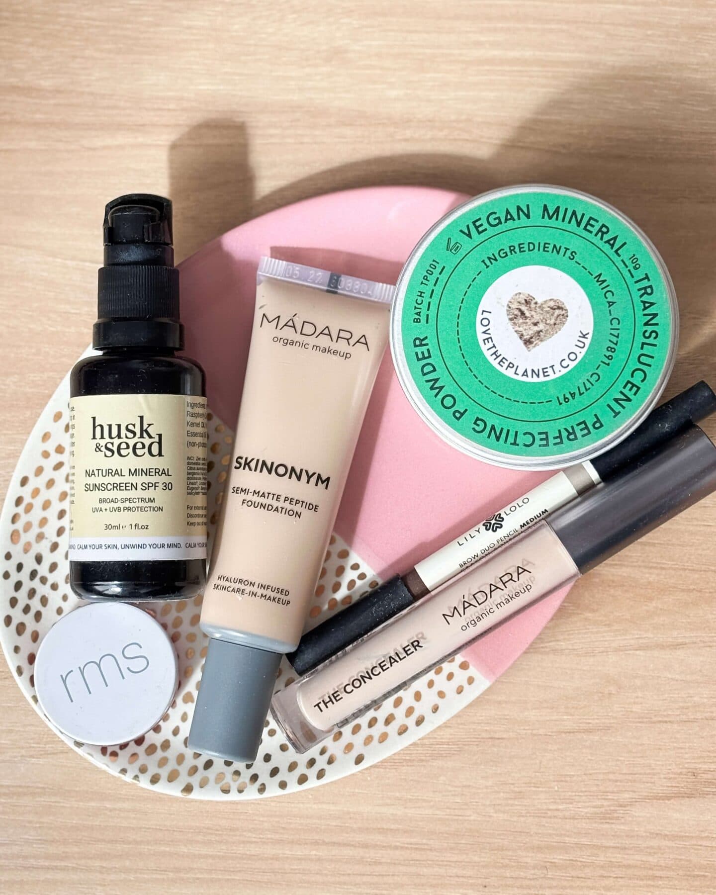 Madara Skinonym Semi-Matte Peptide Foundation with other make-up on a pink dish