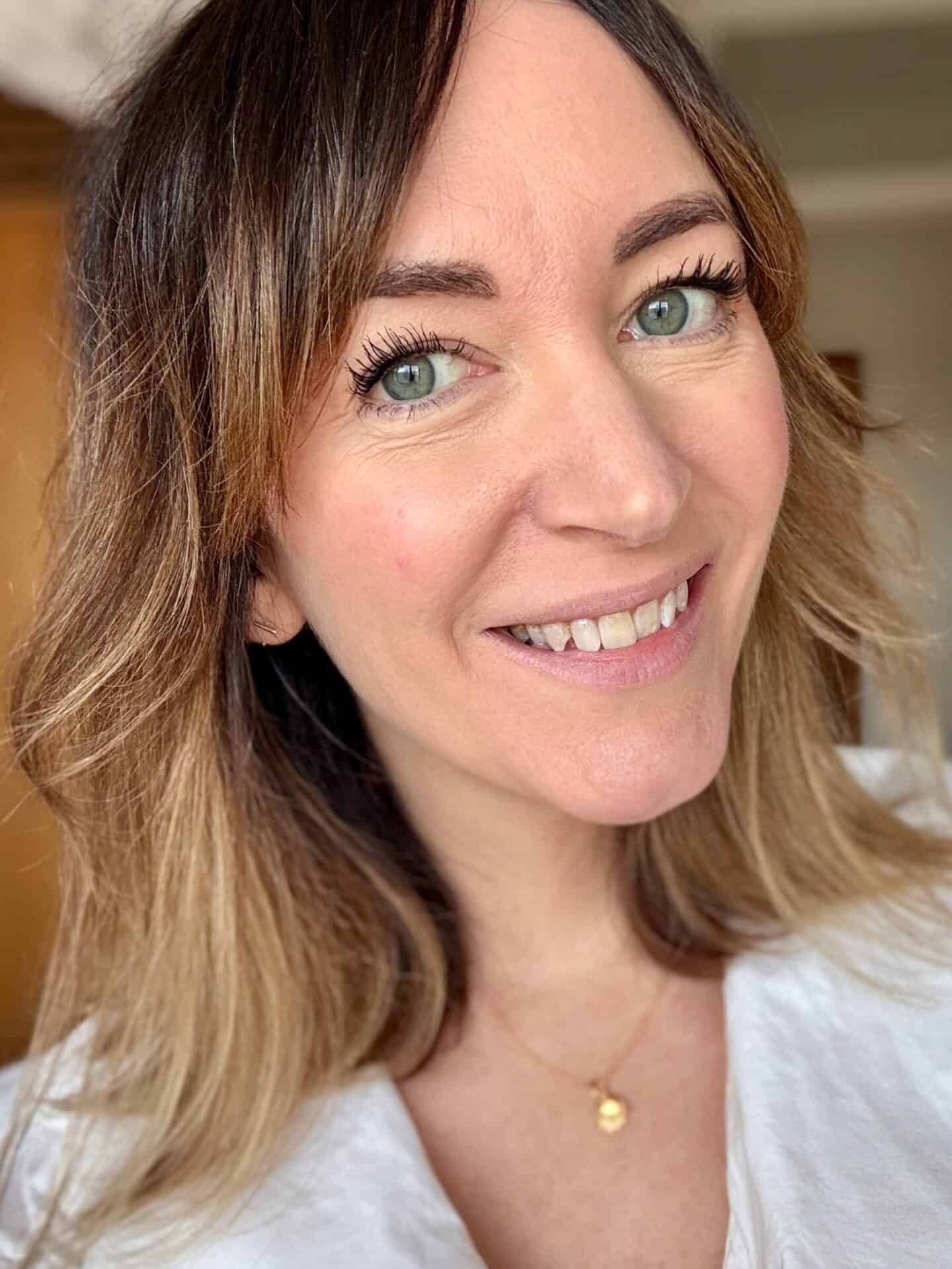 A white woman wearing two coats of Eco by Sonya Mitzi Mascara along with other clean, natural make-up