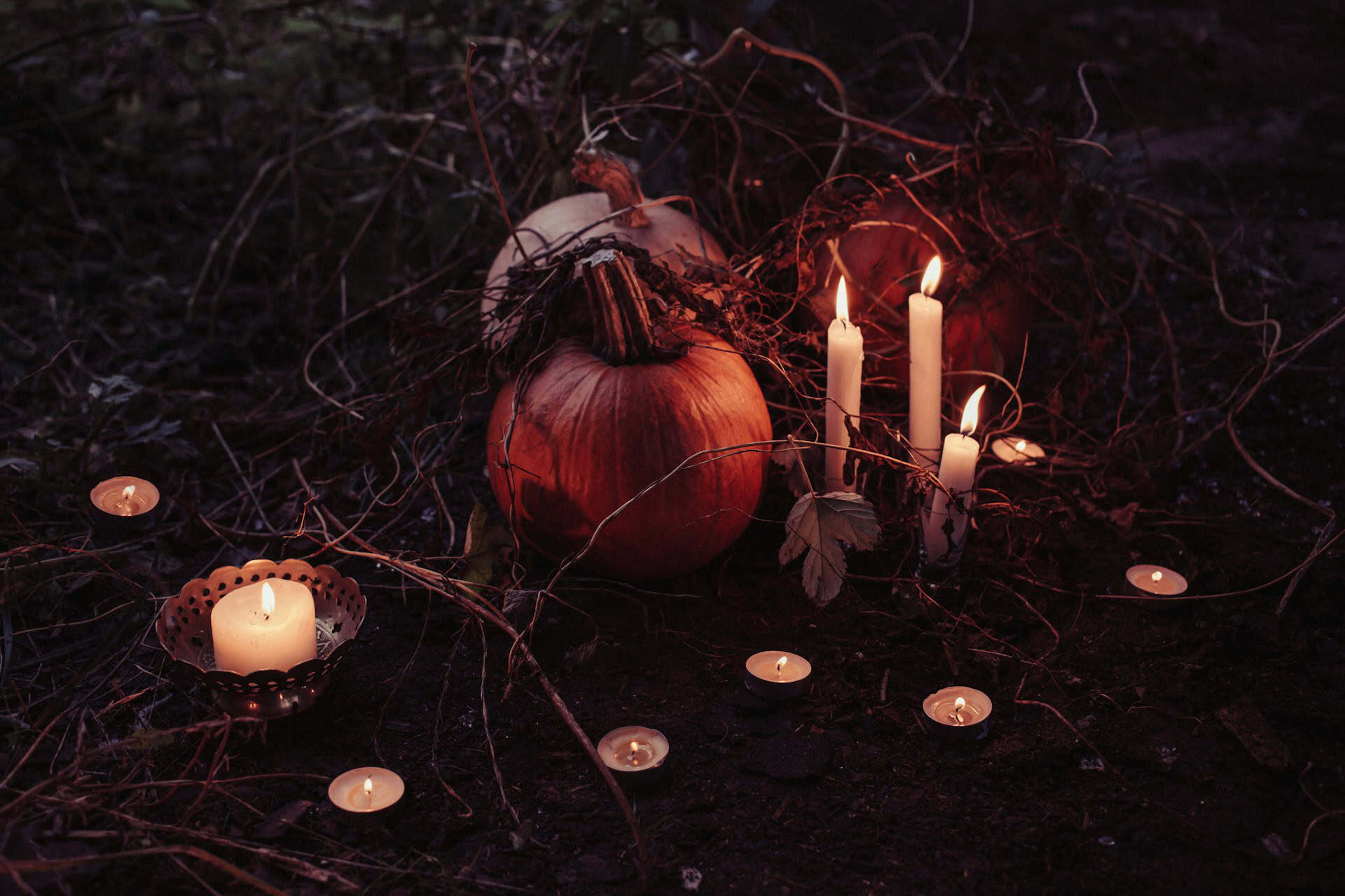 A dark Halloween scene with pumpkins and candles